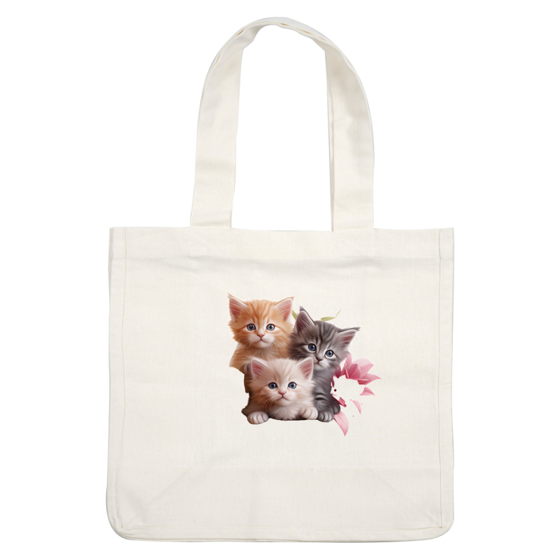 A charming trio of adorable kittens, featuring an orange tabby, a fluffy gray, and a soft white, surrounded by pink flowers. heat press transfers