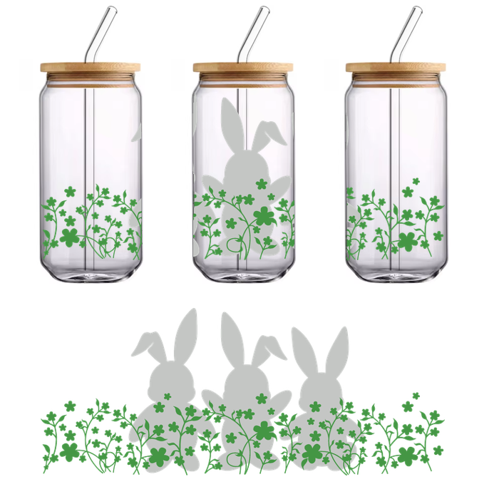 Tres conejos juguetones con motivos florales se encuentran entre tréboles verdes, creando una encantadora escena primaveral.Transferencias UV