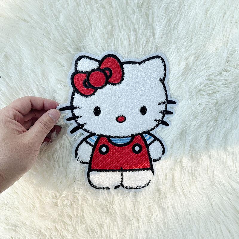 This adorable Hello Kitty plush features her in a red outfit with a matching bow, perfect for cuddles and decor!Patches