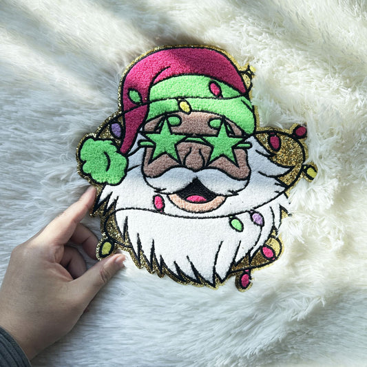 A festive, plush Santa Claus design featuring bright colors, glitter accents, and star-shaped glasses, perfect for holiday decor.Patches