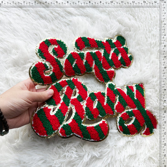 Festive Santa and Baby signage crafted in vibrant red and green yarn, edged with gold for a cheerful holiday touch.Patches