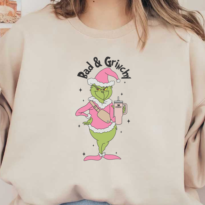 A playful illustration of the Grinch in a pink holiday outfit, holding a Stanley tumbler, exuding a grumpy yet festive vibe.DTF Transfersdtf regular iron