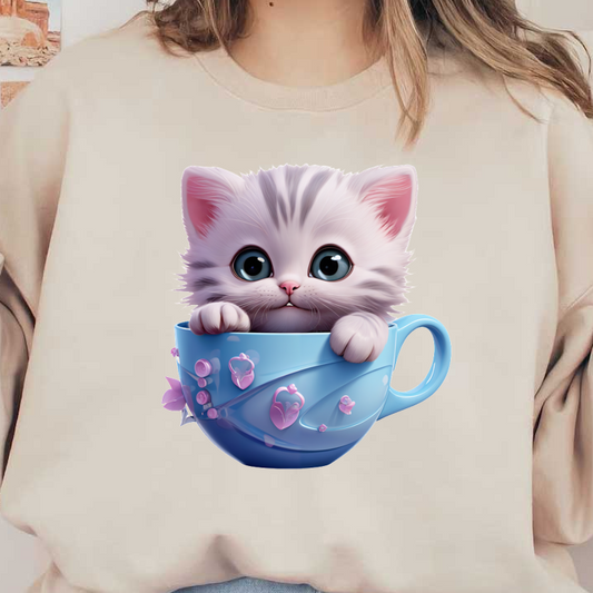 Un lindo y esponjoso gatito con ojos grandes se asoma desde una taza azul claro adornada con pequeñas decoraciones rosas.