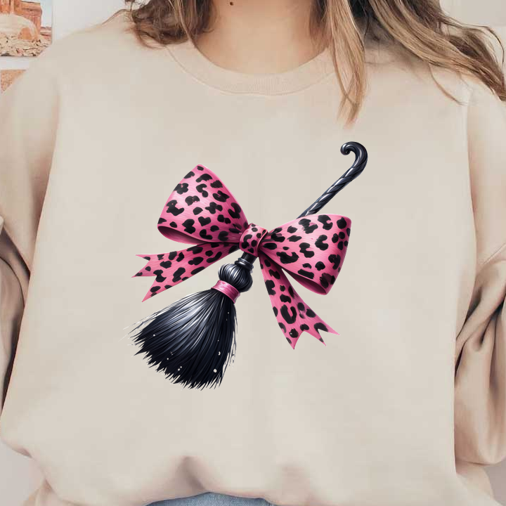 Una elegante varita adornada con un vibrante lazo con estampado de leopardo rosa y una elegante borla negra, perfecta para darle un toque caprichoso.