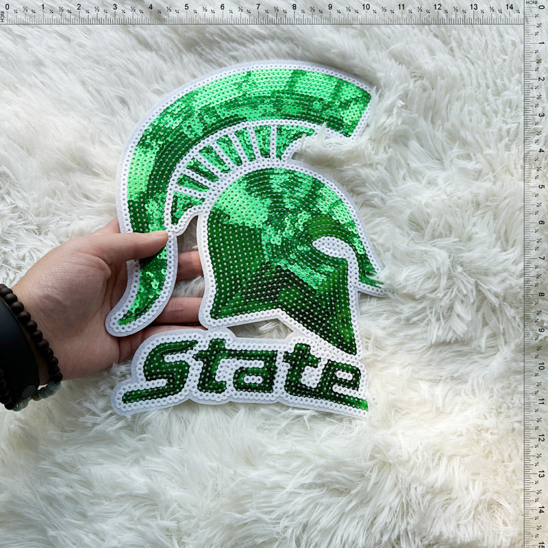 A vibrant green sequin patch featuring a Spartan helmet and the word "State," perfect for spirited decorations.Patches