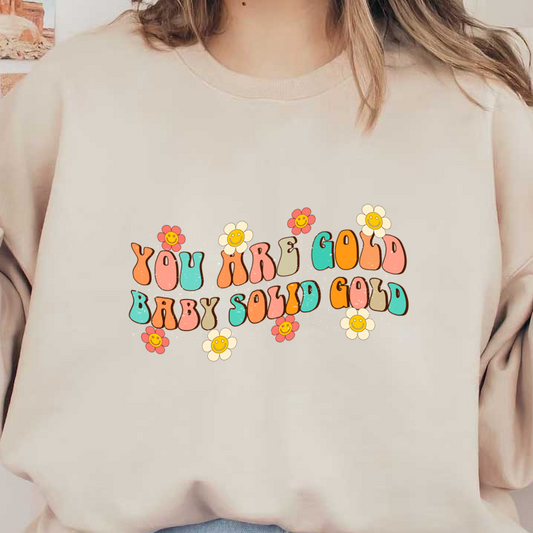 Un diseño alegre y colorido que presenta la frase "You Are Gold Baby Solid Gold" rodeada de flores sonrientes.