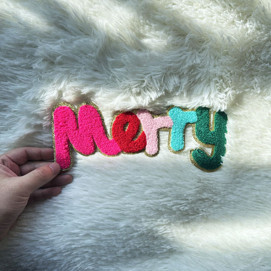 A colorful felt "Merry" decoration accented with gold trim, perfect for festive holiday decor or cheerful gifts.Patches