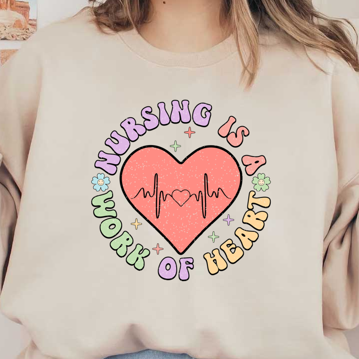 "Celebrate nursing with this colorful graphic featuring a heart, heartbeat line, and the phrase 'Nursing is a work of heart'!"DTF Transfers