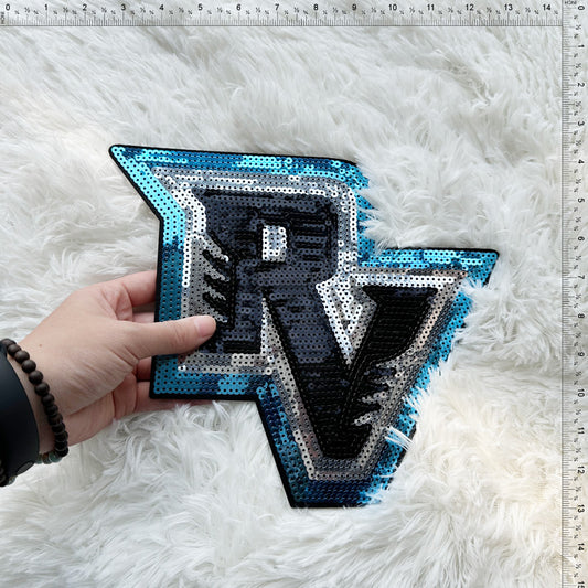 Sparkling and stylish, this sequin badge features a bold "R" design in vibrant blue and black hues, perfect for any fan!Patches