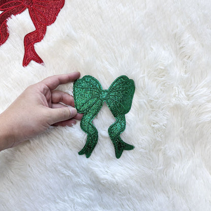 A festive Green/Red small glitter bow applique, perfect for adding a cheerful holiday touch to any garment or craft project.