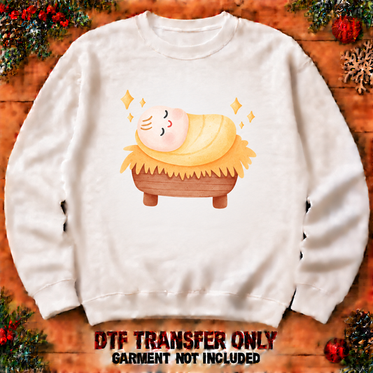 Sleeping baby Jesus in manger DTF transfer shown at 12-inch longest-side scale; garment not included