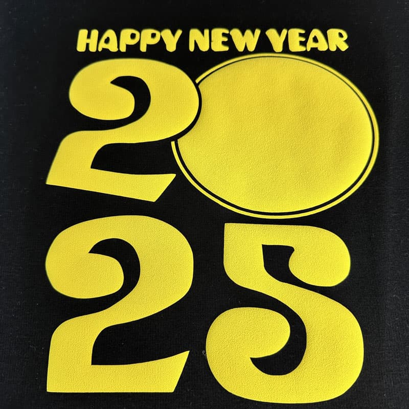 Celebrate in style with this black t-shirt featuring vibrant pink glitter text that reads "Happy New Year 2025."DTF Transfers puff