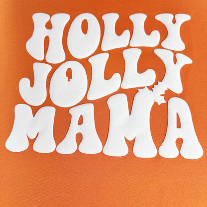 Cheerful retro-style white ‘HOLLY JOLLY MAMA’ text on a vibrant orange background, ideal for festive and fun apparel.DTF Transfers puff