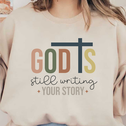 An uplifting design featuring the text "God's still writing your story," accompanied by a cross, in warm, earthy colors.DTF Transfers