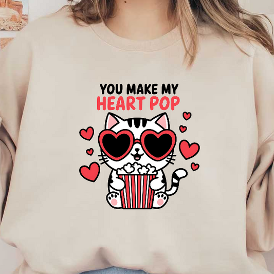 A cute cartoon cat wearing heart-shaped sunglasses holds a bucket of popcorn, with hearts and the phrase "You Make My Heart Pop."DTF Transfers