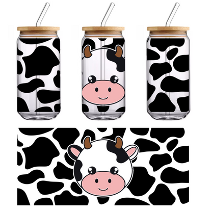 A cute, cartoon-style cow face with black and white patches, small horns, and a cheerful smile.UV Transfers heat press transfers