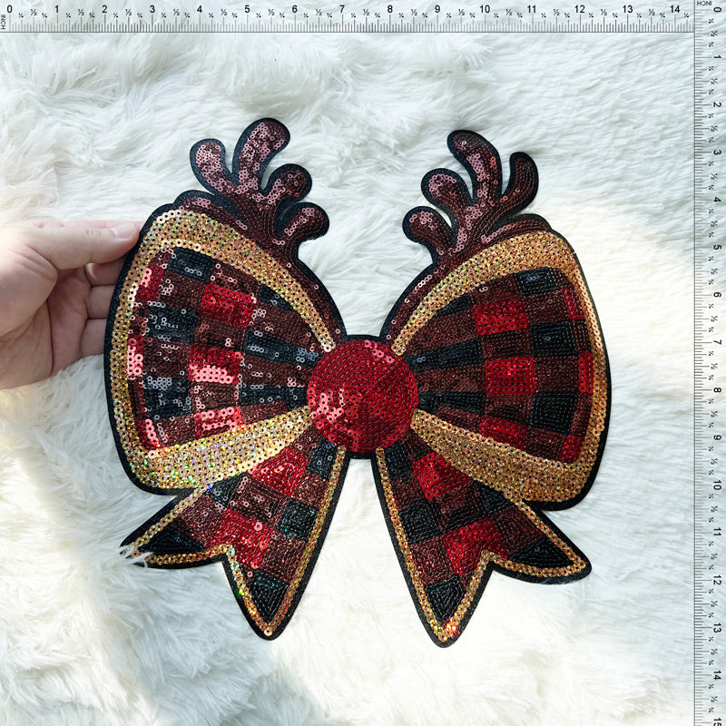 This eye-catching sequin bow features a vibrant plaid pattern in red and black, accented with gold detailing for added sparkle.Patches