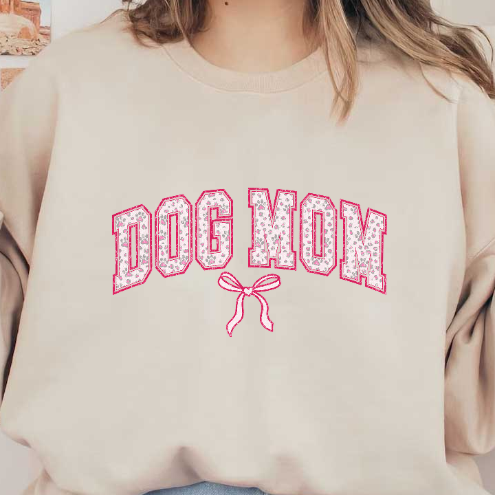 "Dog Mom" pink and white bow and paw print design on a green background.DTF Transfers